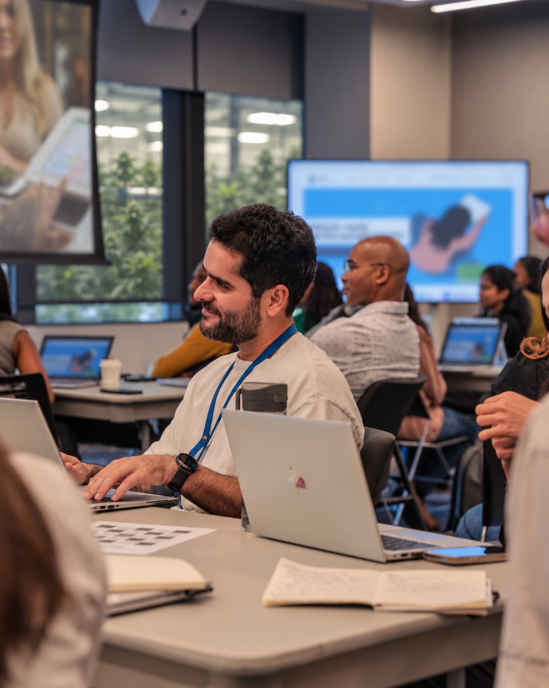A team in a training session with laptops and a presentation
